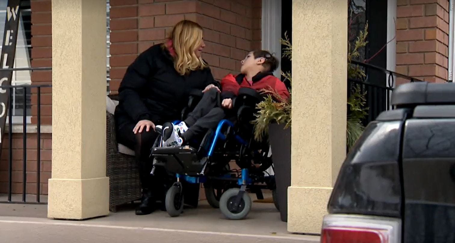 Brenda and her son on the porch of their house.