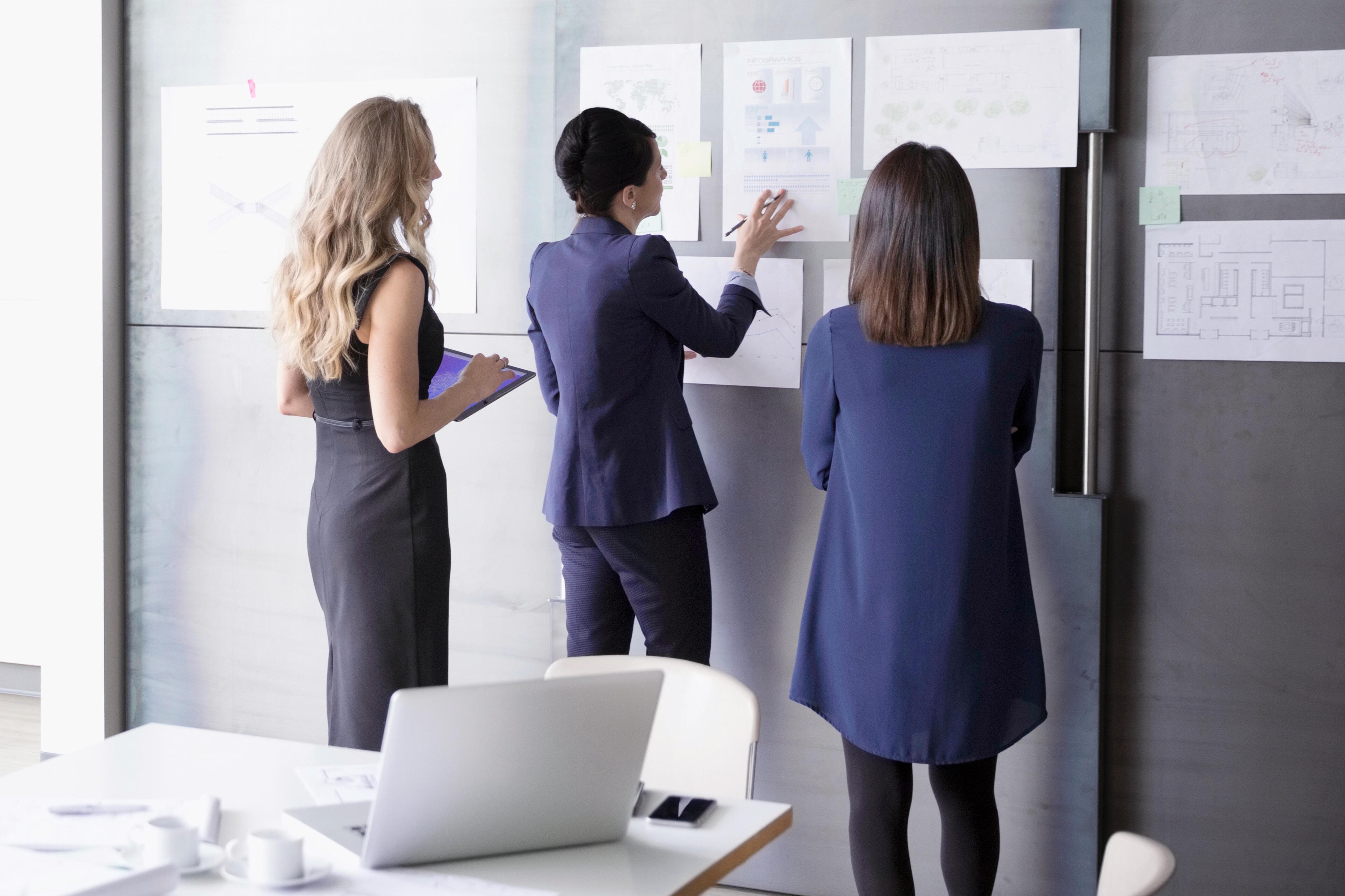 Three ladies working on a board.