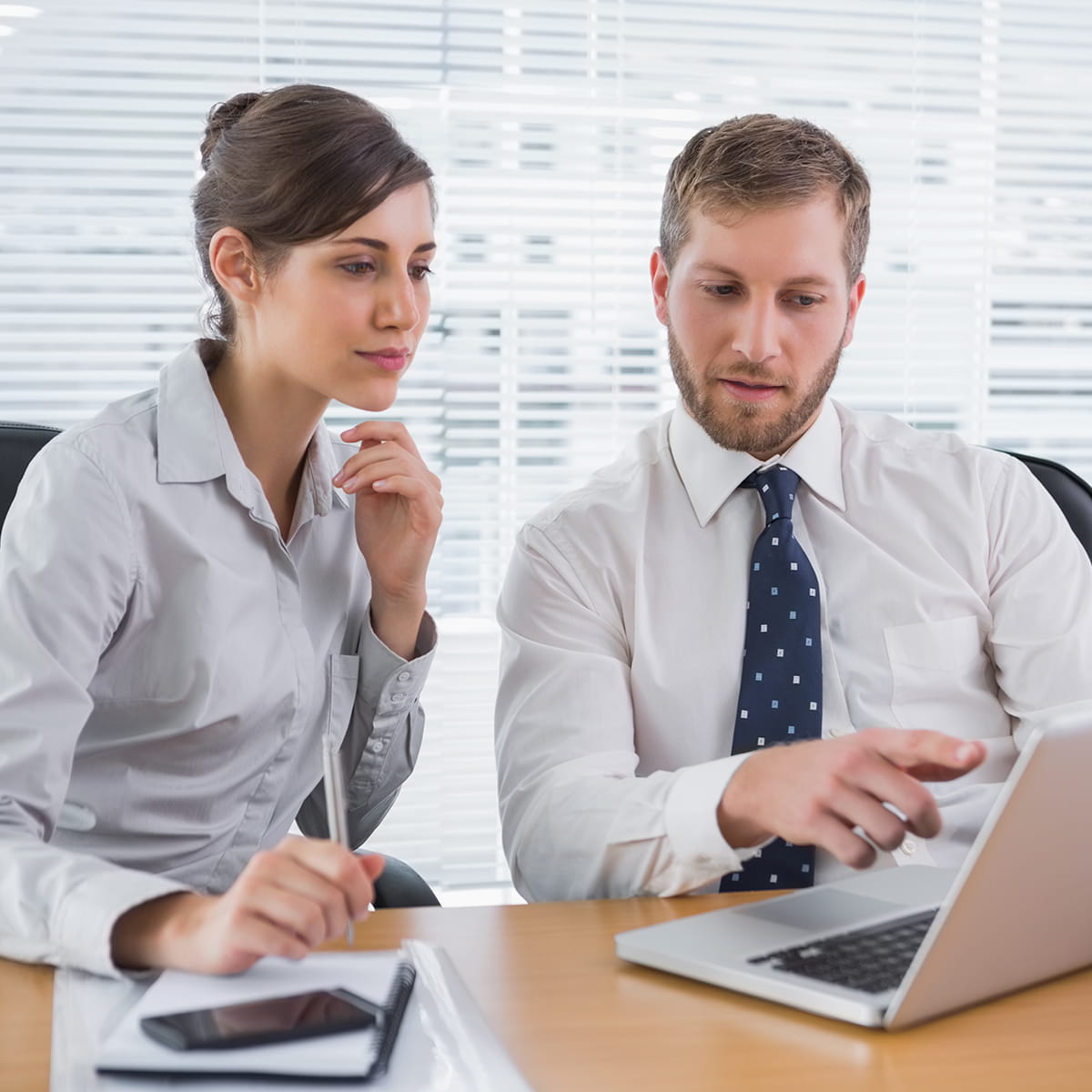 Two people collaborating with a laptop